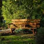 Steigerhouten tuinbank met natuurlijke patinalaag in een tuin