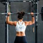 Man traint thuis met dumbbells - thuis sportschool setup met minimale apparatuur voor fitness