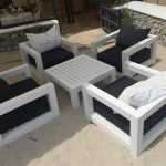 Steigerhouten loungeset met kussens op terras, ideaal voor ontspanning in de tuin
