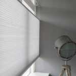 Verano sfeerafbeelding met mooie plisségordijnen in een modern interieur met verschillende transparantiesoorten