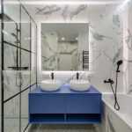 Moderne badkamer met badkamertrends: glazen inloopdouche, natuurstenen wastafel en elegante inrichting