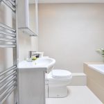 Moderne ensuite badkamer met wastafelmeubel en natuurlijke materialen, direct verbonden met slaapkamer