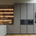 Moderne keuken met geïntegreerde afzuiging in de kookplaat, lichte materialen en open planken voor een ruimtelijk effect