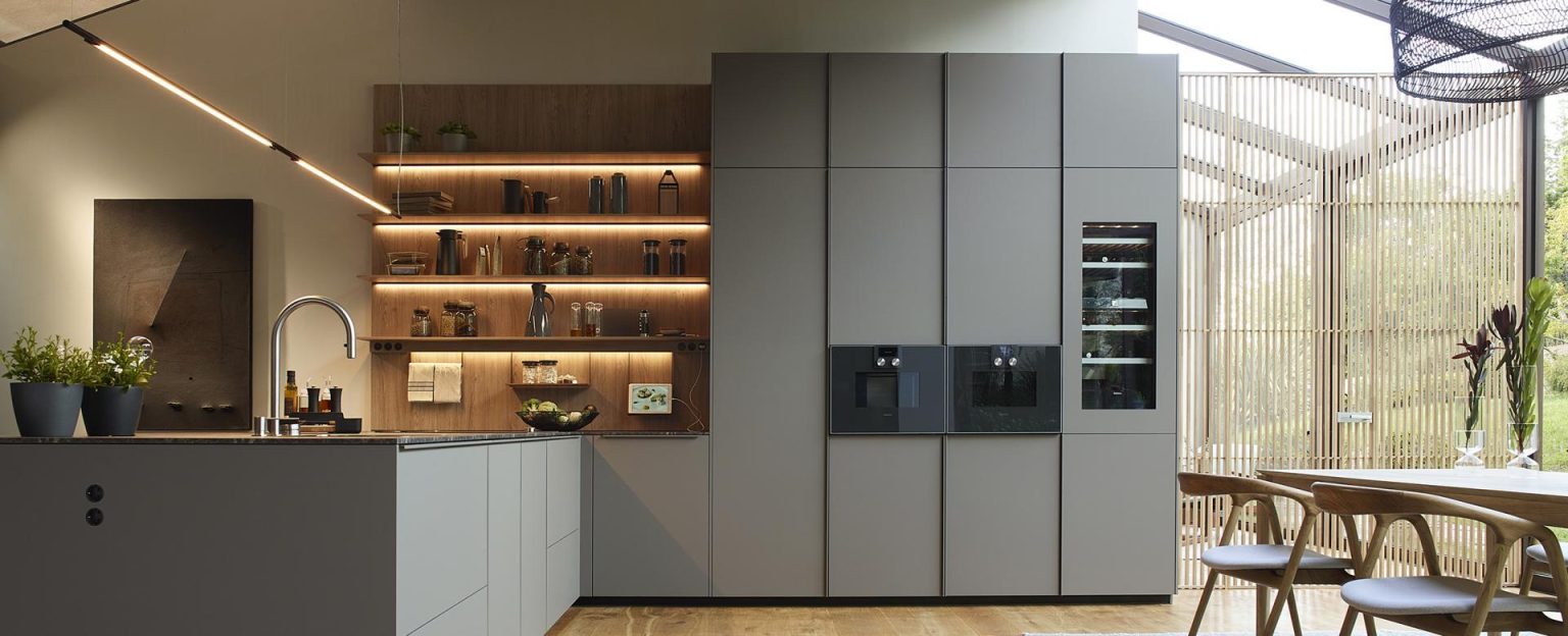 Moderne keuken met geïntegreerde afzuiging in de kookplaat, lichte materialen en open planken voor een ruimtelijk effect